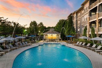 A large swimming pool surrounded by lounge chairs and umbrellas.